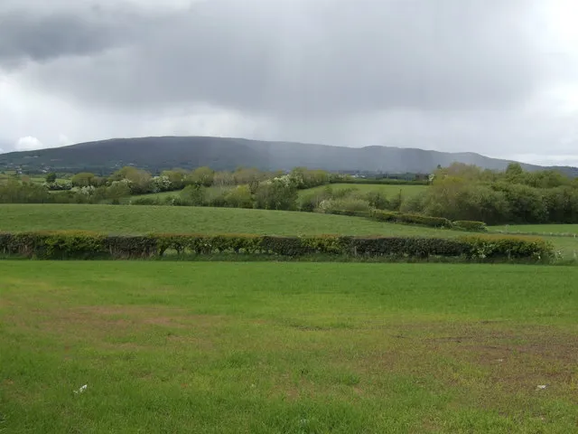 Bewolkte, regenachtige velden op het Ierse platteland met donkere wolken over de heuvels.